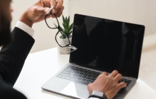 Cropped image of businessman using laptop with blank screen